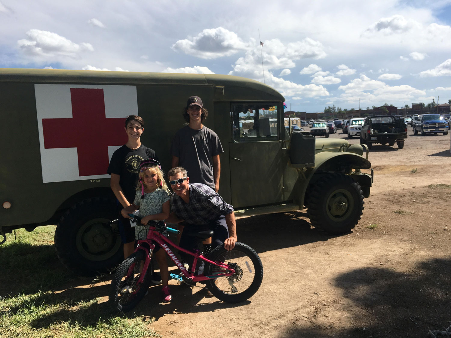 Jared Fisher standing with family in front of a military truck