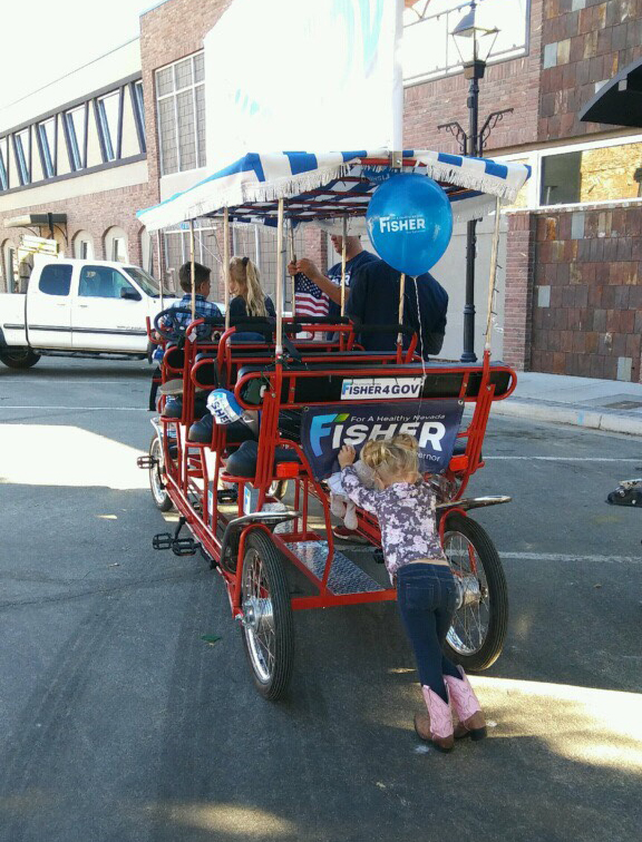 Girl helping push Fisher for Nevada bike in Nevada Day parade